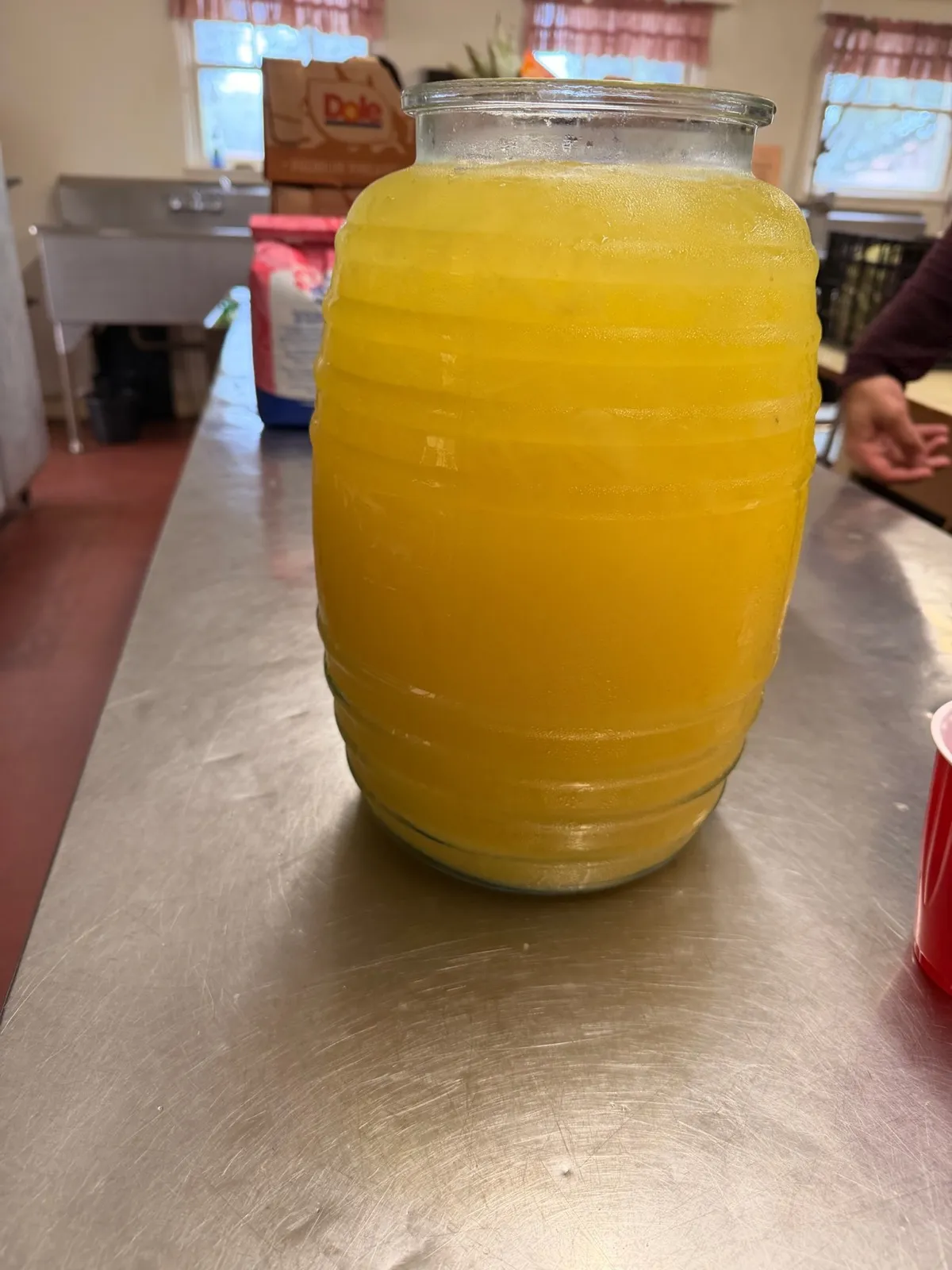 A large glass jar of fresh aguas frescas set out on the serving table