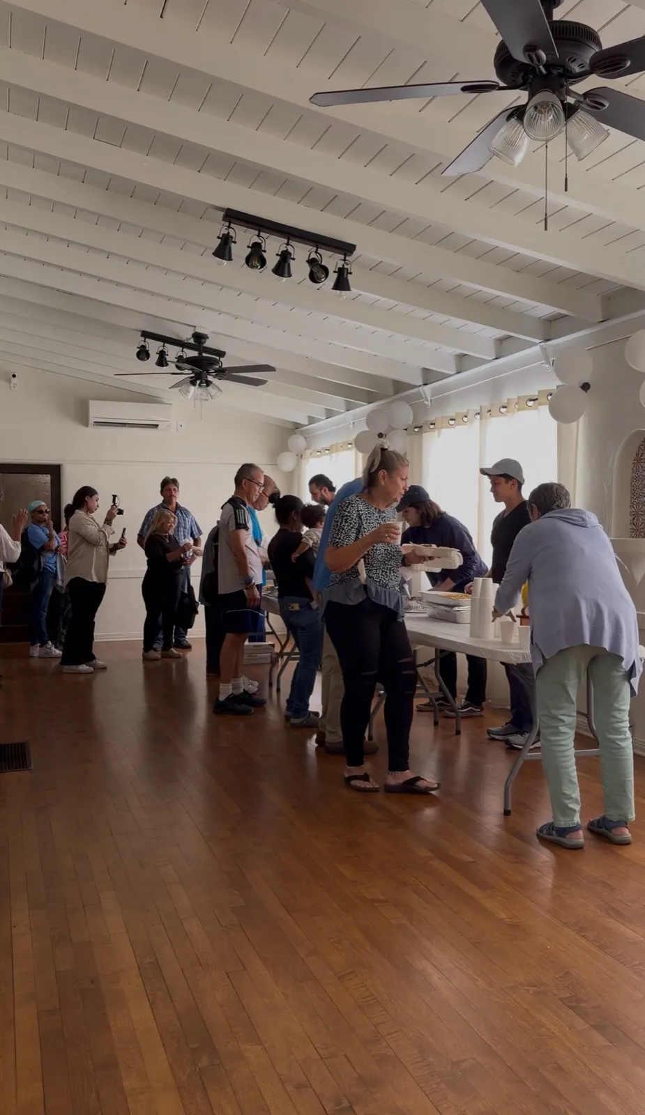 Volunteers plating tacos along the serving line as guests come through